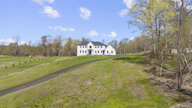 view of front facade with a front lawn and a wooded view