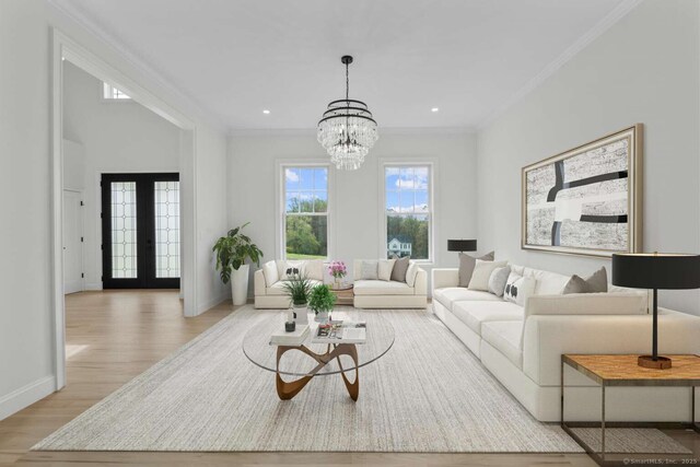 living area featuring ornamental molding, wood finished floors, baseboards, a chandelier, and french doors