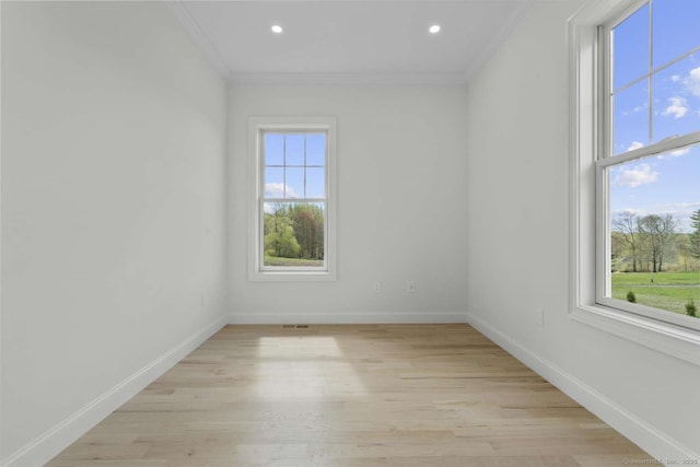 empty room with baseboards, ornamental molding, recessed lighting, and light wood-style flooring