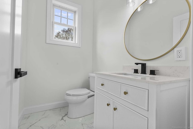 bathroom with baseboards, vanity, toilet, and marble finish floor