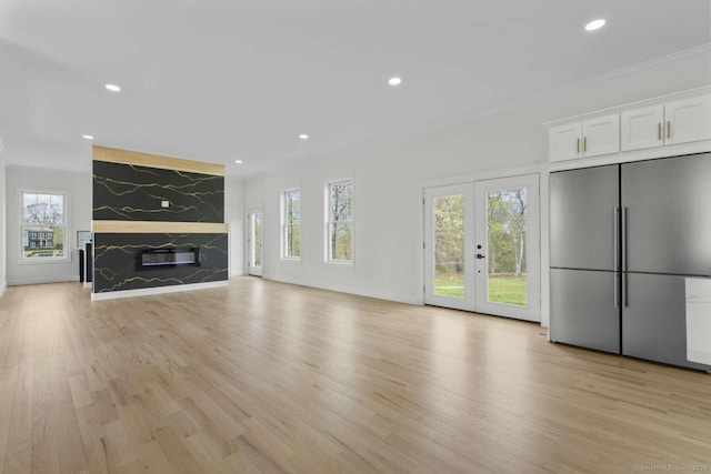 unfurnished living room with light wood-style floors, recessed lighting, and a wealth of natural light