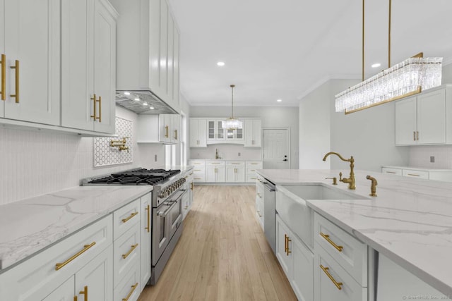 kitchen featuring a sink, white cabinets, light wood finished floors, stainless steel appliances, and recessed lighting