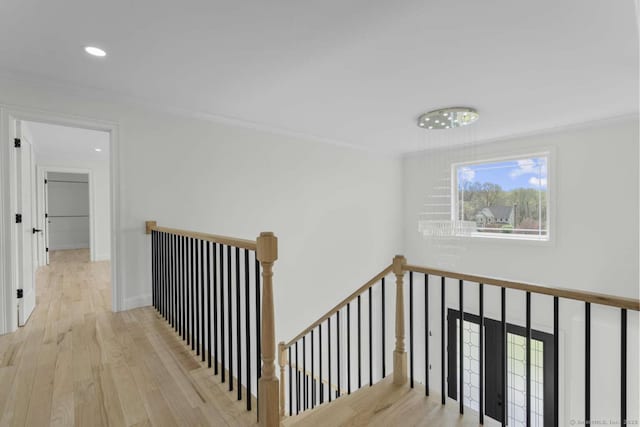 hall featuring crown molding, wood finished floors, and an upstairs landing