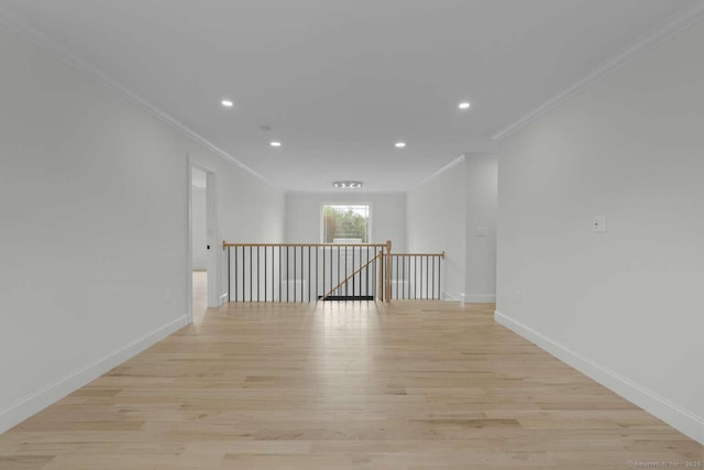 spare room featuring crown molding, recessed lighting, light wood-style floors, and baseboards