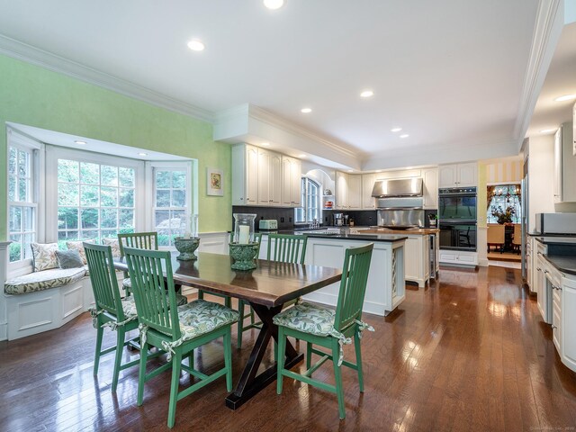 dining space with crown molding, dark wood-style floors, and recessed lighting