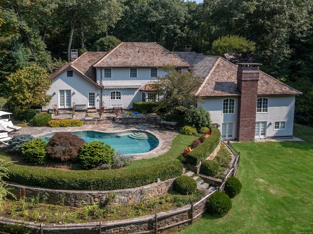 outdoor pool featuring french doors, a yard, and a patio