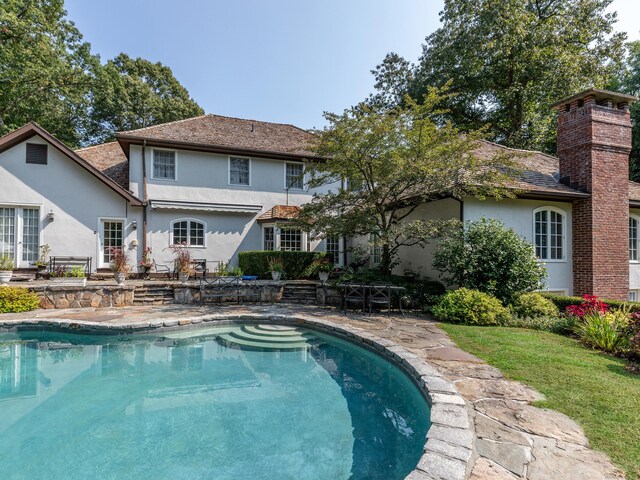 swimming pool featuring a patio and a lawn
