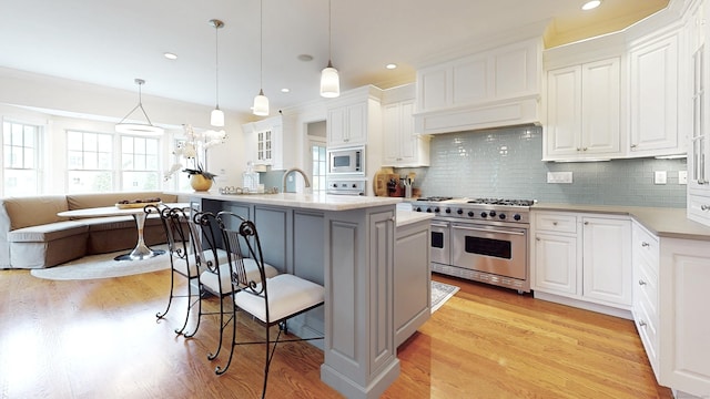 27 Dock Rd, Milford, CT 06460 - kitchen featuring light countertops, a breakfast bar area, stainless steel appliances, and white cabinetry