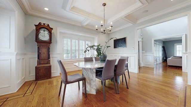 27 Dock Rd, Milford, CT 06460 - dining area featuring ornamental molding, a decorative wall, light wood-style flooring, and a notable chandelier