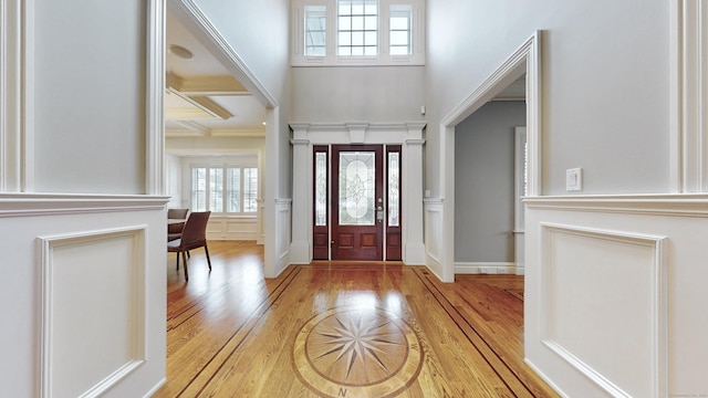27 Dock Rd, Milford, CT 06460 - foyer entrance with wainscoting, wood finished floors, ornamental molding, a high ceiling, and a decorative wall