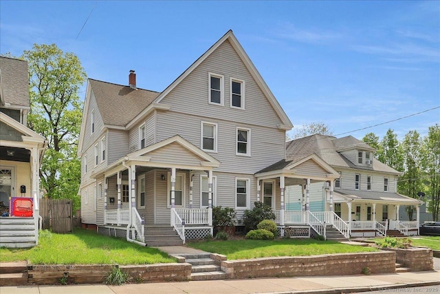 view of front of home featuring a porch, a chimney, and a front lawn