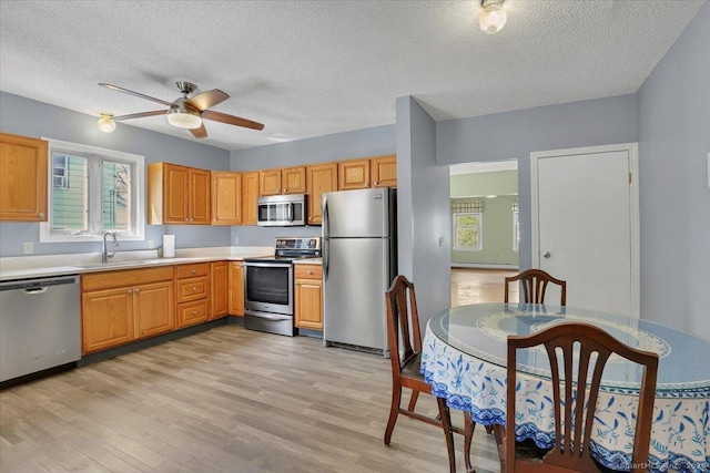 kitchen featuring a textured ceiling, appliances with stainless steel finishes, a wealth of natural light, and ceiling fan