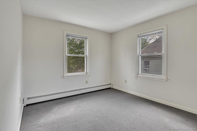 carpeted empty room featuring baseboards, a baseboard heating unit, a textured ceiling, and a wealth of natural light