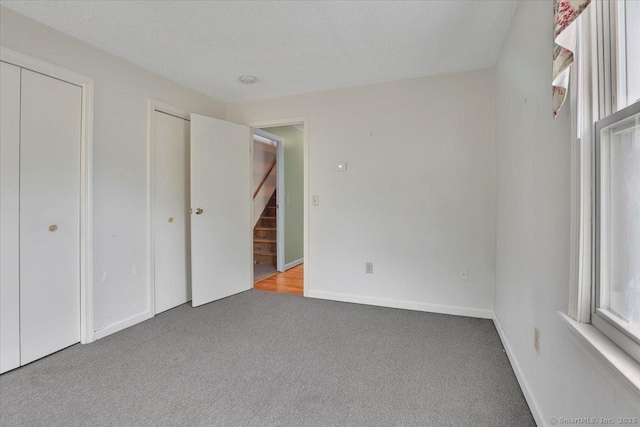 unfurnished bedroom featuring baseboards and carpet