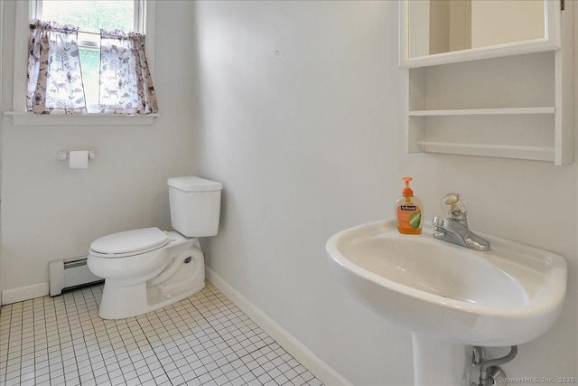 bathroom with a sink, toilet, tile patterned floors, baseboards, and a baseboard heating unit