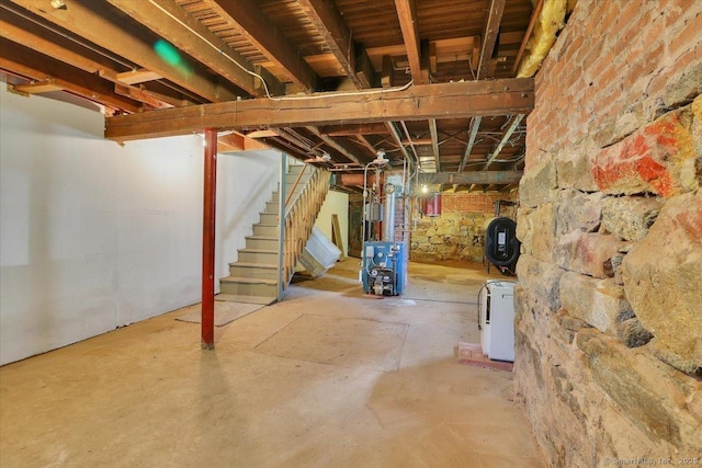 unfinished below grade area with heating fuel, stairs, and a heating unit