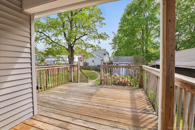 wooden deck with a fenced backyard, a storage unit, an outbuilding, and a residential view