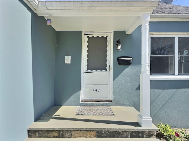 141 Arcadia Ave, Bridgeport, CT 06604 - view of exterior entry with a shingled roof and stucco siding