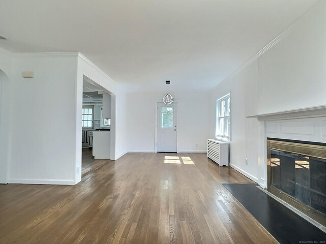 141 Arcadia Ave, Bridgeport, CT 06604 - unfurnished living room featuring crown molding, radiator, a glass covered fireplace, and wood finished floors