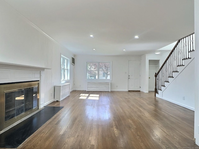 141 Arcadia Ave, Bridgeport, CT 06604 - unfurnished living room featuring a glass covered fireplace, radiator heating unit, baseboards, wood finished floors, and stairway
