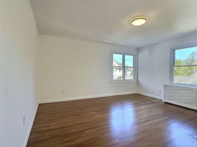 141 Arcadia Ave, Bridgeport, CT 06604 - spare room with baseboards, radiator heating unit, and dark wood-style floors
