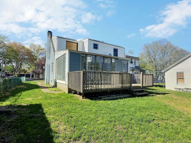 141 Arcadia Ave, Bridgeport, CT 06604 - back of house featuring a lawn, a sunroom, a chimney, and a deck