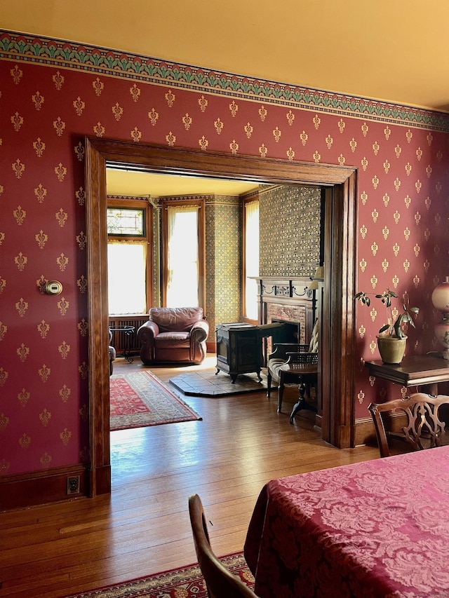 bedroom with baseboards, radiator, hardwood / wood-style floors, and wallpapered walls