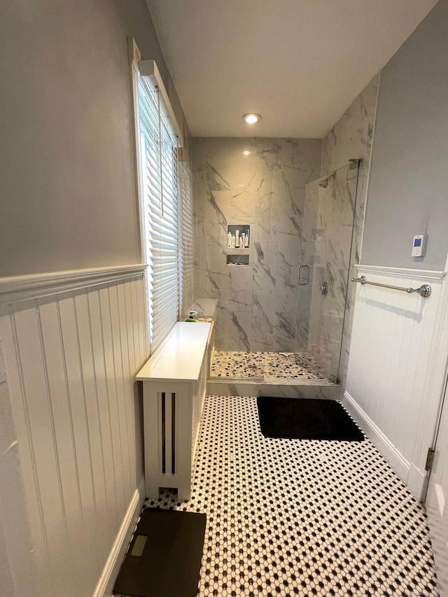 full bathroom with recessed lighting, a marble finish shower, a decorative wall, and wainscoting