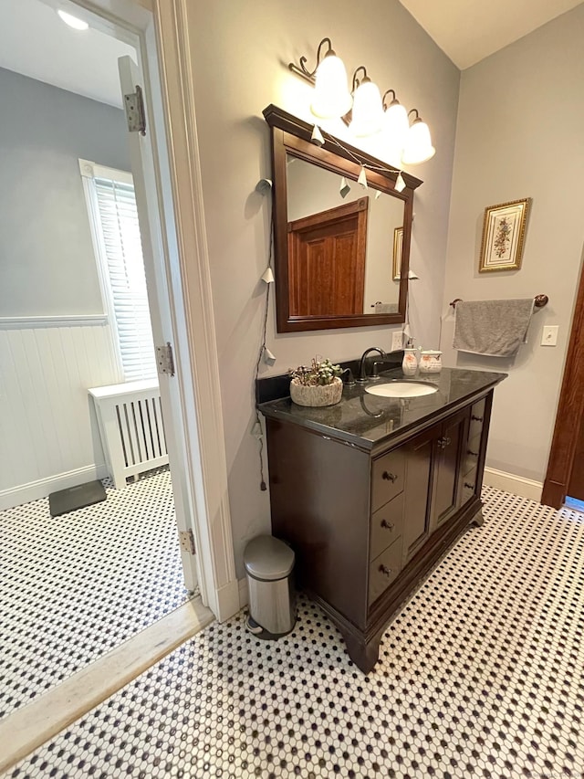 bathroom featuring radiator heating unit, vanity, a wainscoted wall, and tile patterned floors