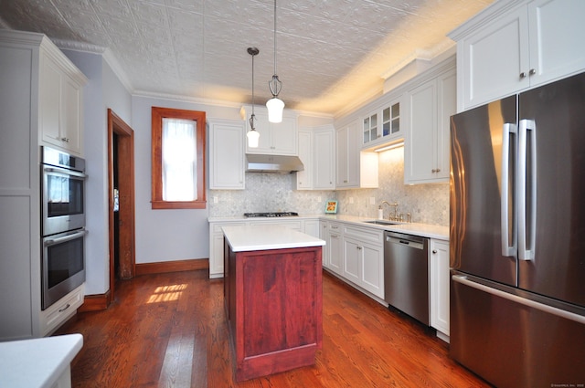 1123 Windsor Ave, Windsor, CT 06095 - kitchen with stainless steel appliances, under cabinet range hood, baseboards, light countertops, and decorative backsplash