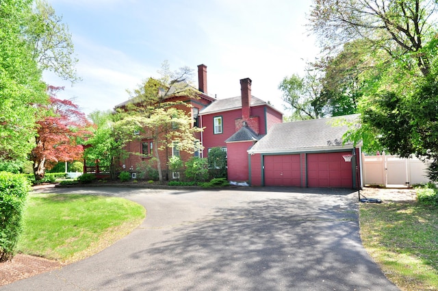 1123 Windsor Ave, Windsor, CT 06095 - view of side of property featuring driveway, fence, a garage, and a chimney