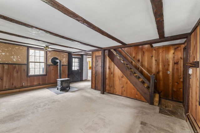 interior space with wood walls, carpet, stairs, and beamed ceiling