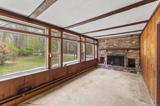 unfurnished sunroom featuring carpet floors, beam ceiling, wooden walls, and baseboard heating