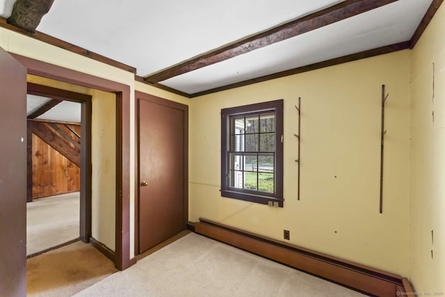empty room with light colored carpet, a baseboard radiator, baseboards, and beamed ceiling