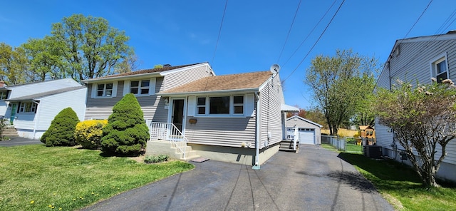 116 Aimes Dr, West Haven, CT 06516 - split level home with a front yard, an outbuilding, a detached garage, fence, and cooling unit