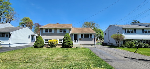 116 Aimes Dr, West Haven, CT 06516 - tri-level home featuring driveway, a chimney, and a front yard