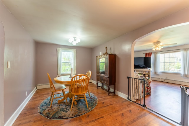 23 Strosberg Rd, Waterford, CT 06385 - dining room featuring wood finished floors, arched walkways, and a baseboard heating unit