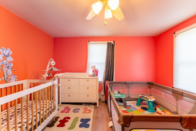 23 Strosberg Rd, Waterford, CT 06385 - bedroom with a crib, ceiling fan, and wood finished floors