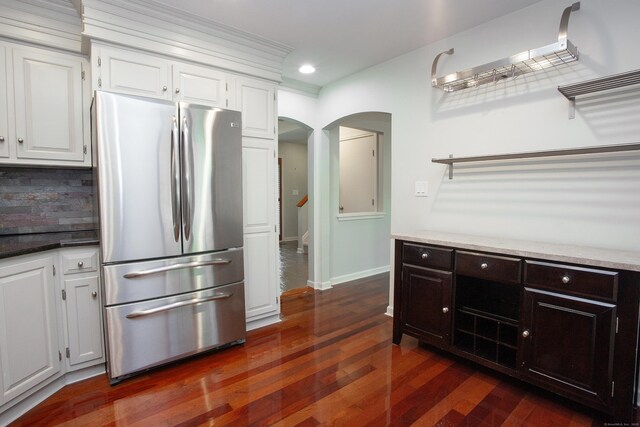 22 Maple Ln Unit 22, Avon, CT 06001 - kitchen with freestanding refrigerator, arched walkways, dark wood-style flooring, tasteful backsplash, and white cabinetry