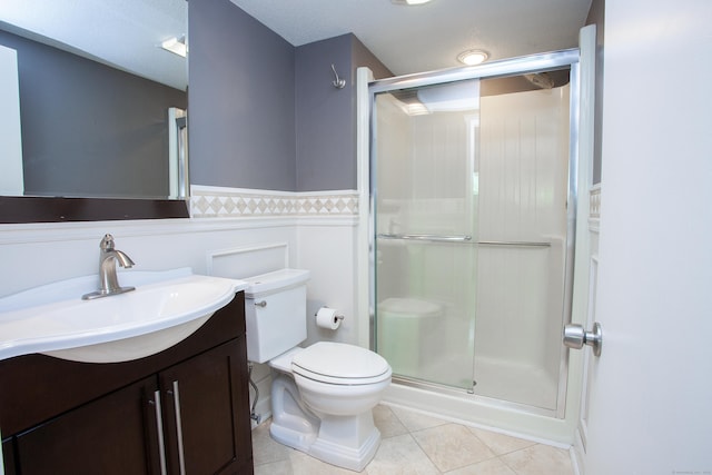 22 Maple Ln Unit 22, Avon, CT 06001 - bathroom with tile patterned flooring, a stall shower, toilet, vanity, and a wainscoted wall