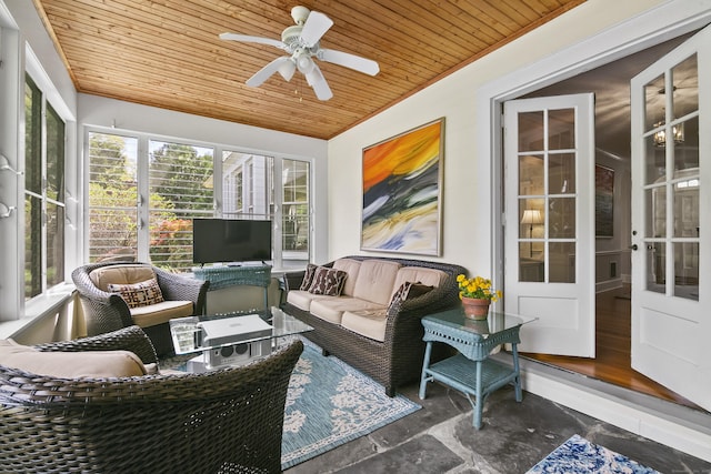 sunroom with stone tile floors, a ceiling fan, wooden ceiling, and an outdoor hangout area