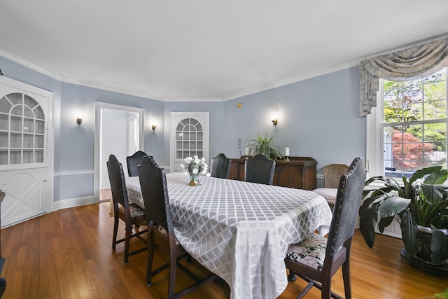 dining space featuring ornamental molding and wood finished floors