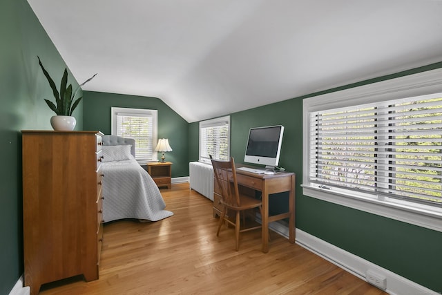 bedroom with wood finished floors, baseboards, lofted ceiling, and radiator heating unit