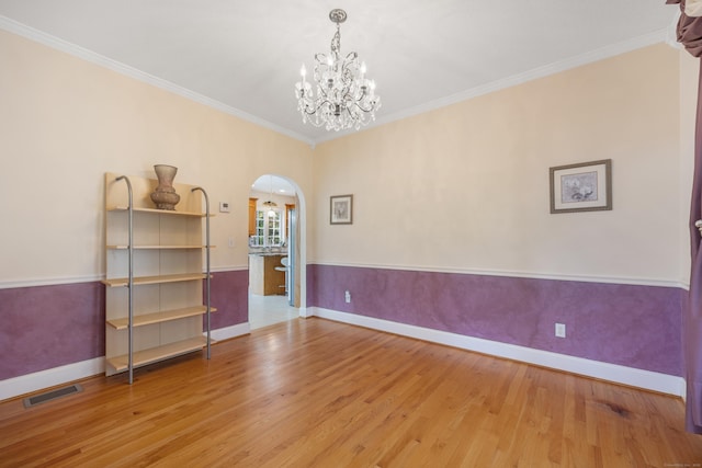 85 Chippenwood Ln, Bristol, CT 06010 - unfurnished room with visible vents, arched walkways, wood finished floors, baseboards, and an inviting chandelier