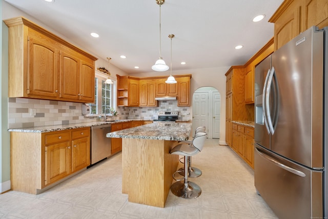 85 Chippenwood Ln, Bristol, CT 06010 - kitchen featuring stainless steel appliances, light stone countertops, a center island, and light floors
