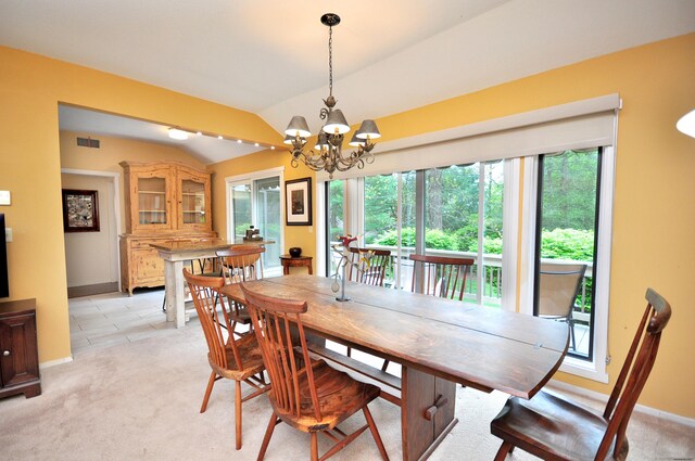 dining room featuring healthy amount of natural light, vaulted ceiling, a chandelier, baseboards, and light carpet