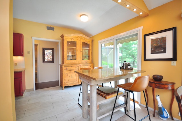 dining area featuring vaulted ceiling and baseboards