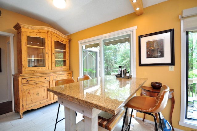 dining area featuring healthy amount of natural light and vaulted ceiling