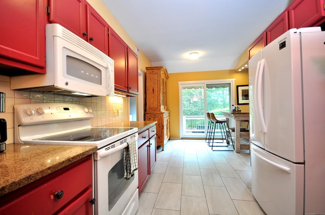 kitchen with white appliances, tasteful backsplash, baseboards, and dark brown cabinets