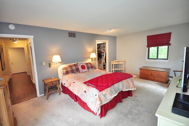 carpeted bedroom with a spacious closet, baseboards, and a closet